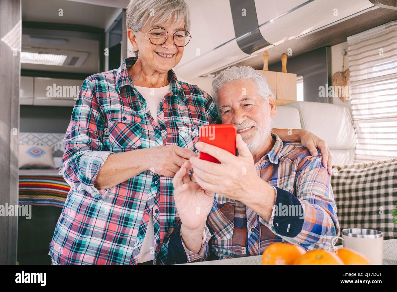 Smiling senior couple using smart phone at motor home Stock Photo