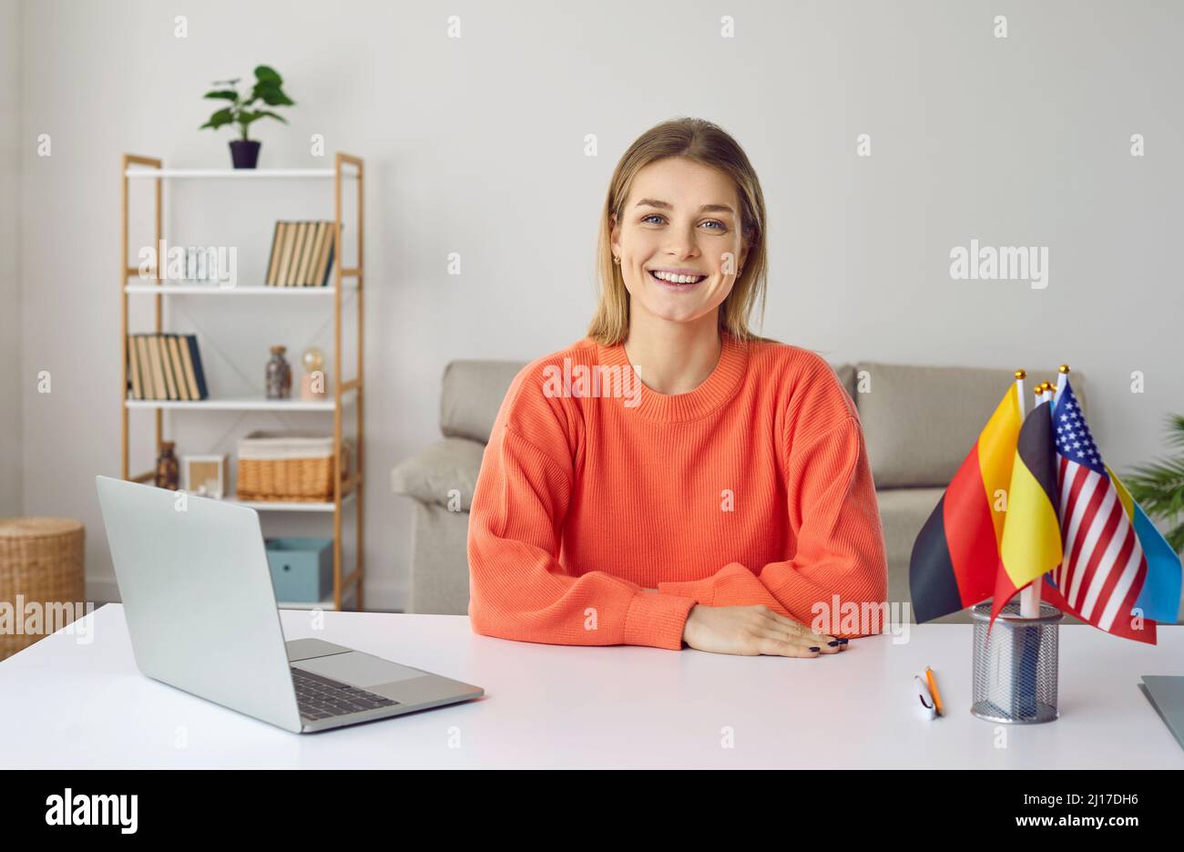 Happy student with laptop and flags of foreign countries studying at international online university Stock Photo