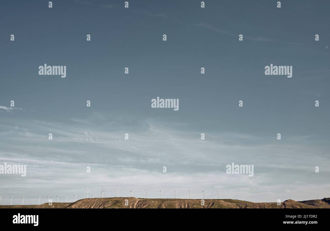 Wind turbines on land under cloudy sky Stock Photo - Alamy
