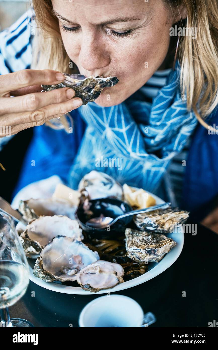 Tourist eating oysters at vacations Stock Photo Alamy