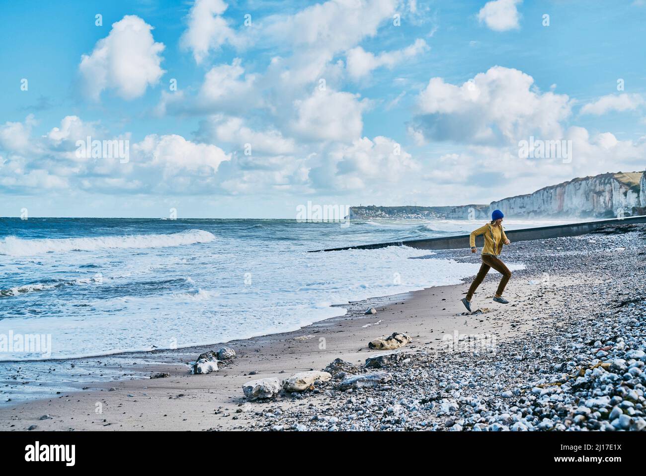 Woman running in front of sea at beach Stock Photo