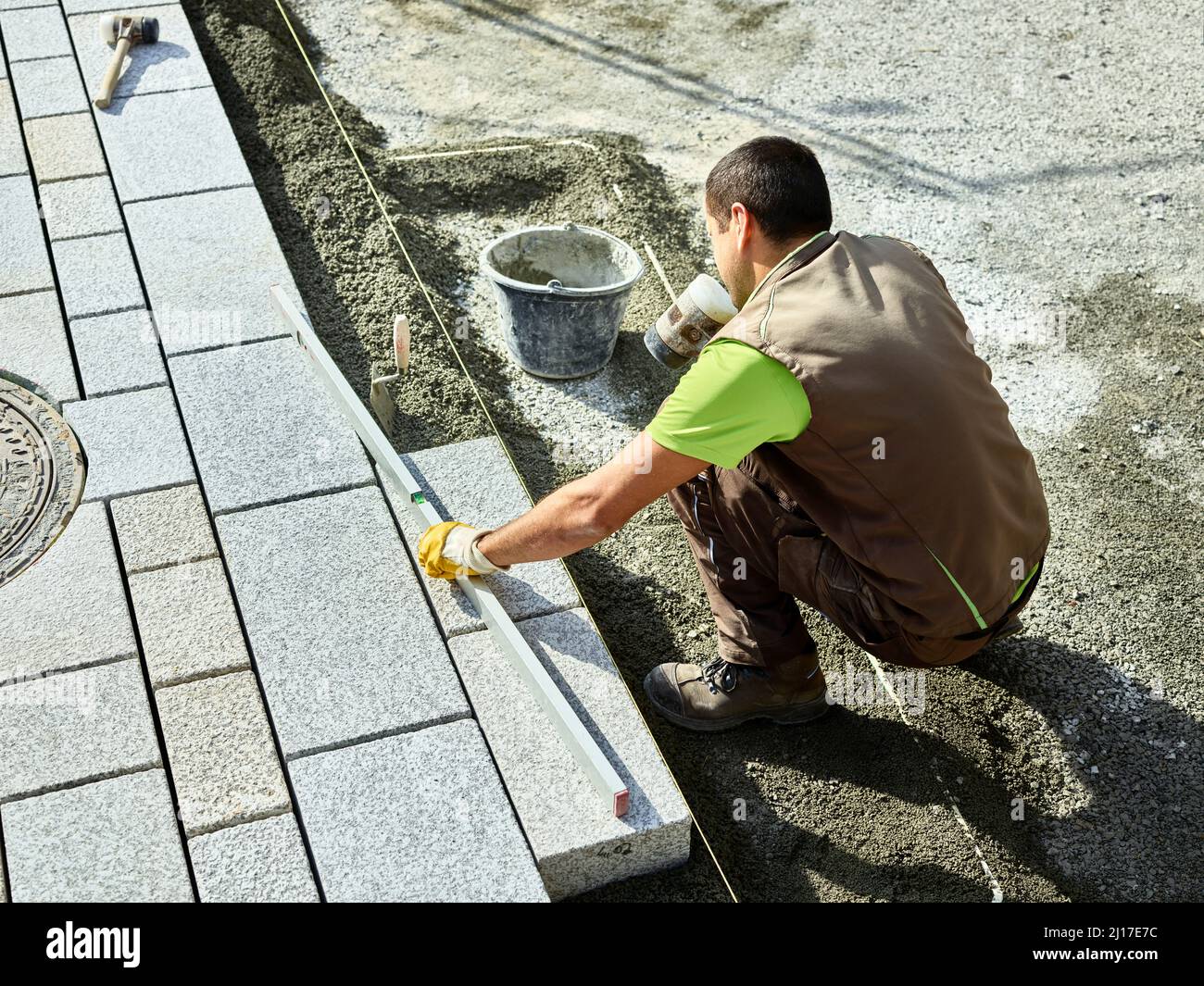 Paver examining paving stone with level Stock Photo Alamy