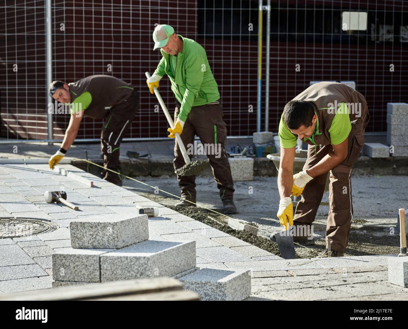 Pavers laying cement on footpath Stock Photo Alamy
