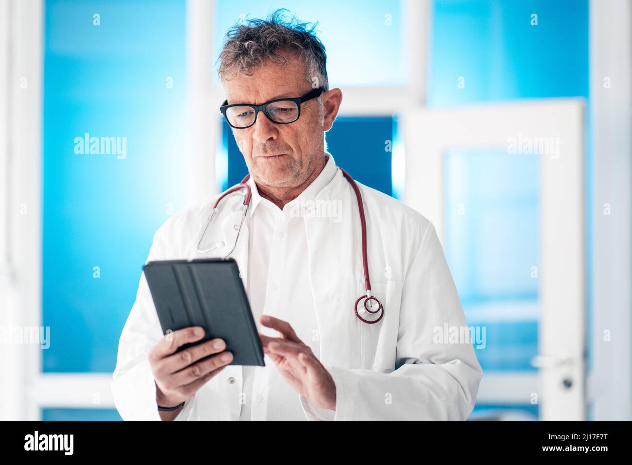 Doctor with stethoscope using digital tablet PC at clinic Stock Photo