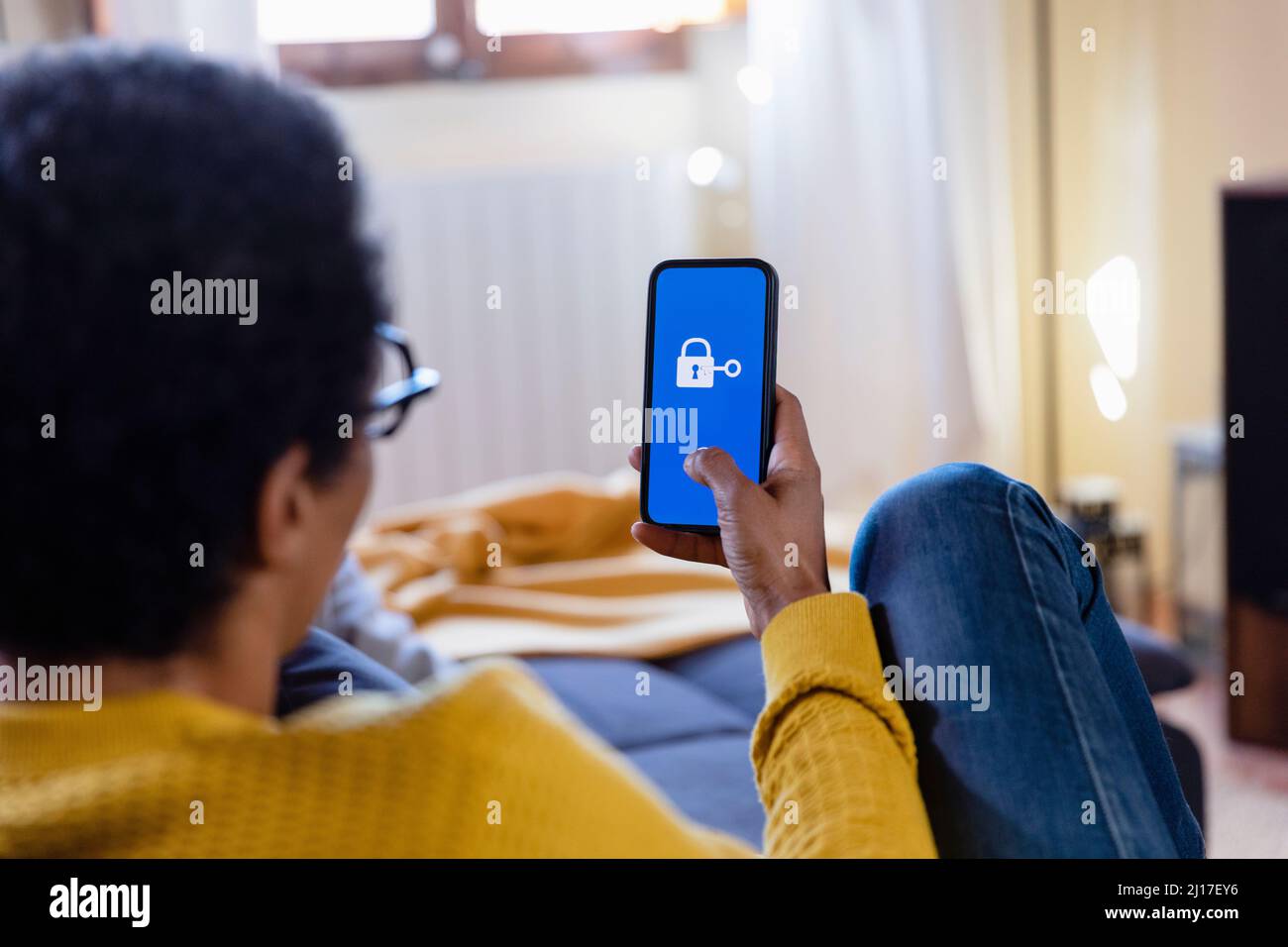 Woman using mobile phone at home Stock Photo