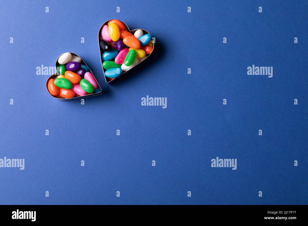 Directly above view of heart shape containers with colorful candies by