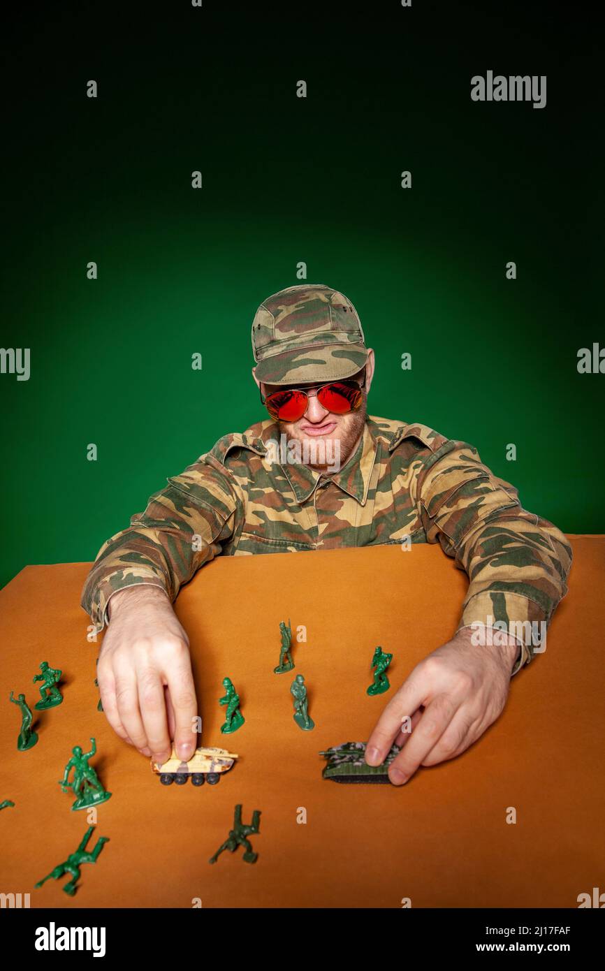 Young military soldier with army figurines and tanks on table Stock Photo