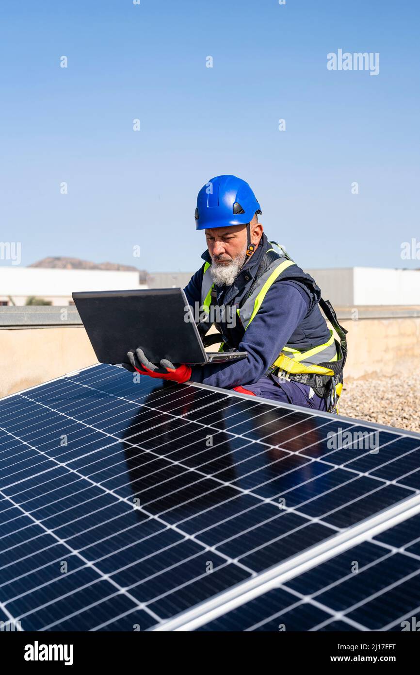 Engineer working on laptop by solar panels Stock Photo
