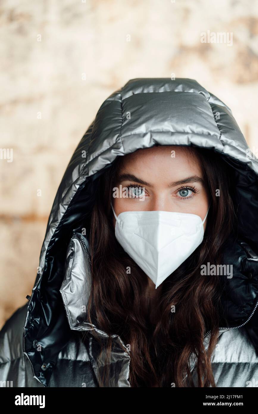 Woman with warm clothing wearing protective face mask Stock Photo