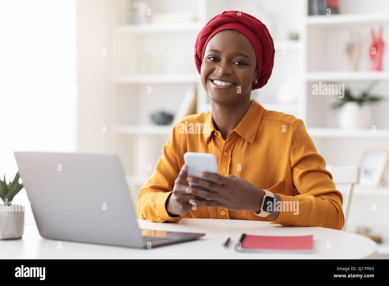 African businesswoman laptop using smartphone hi-res stock photography ...
