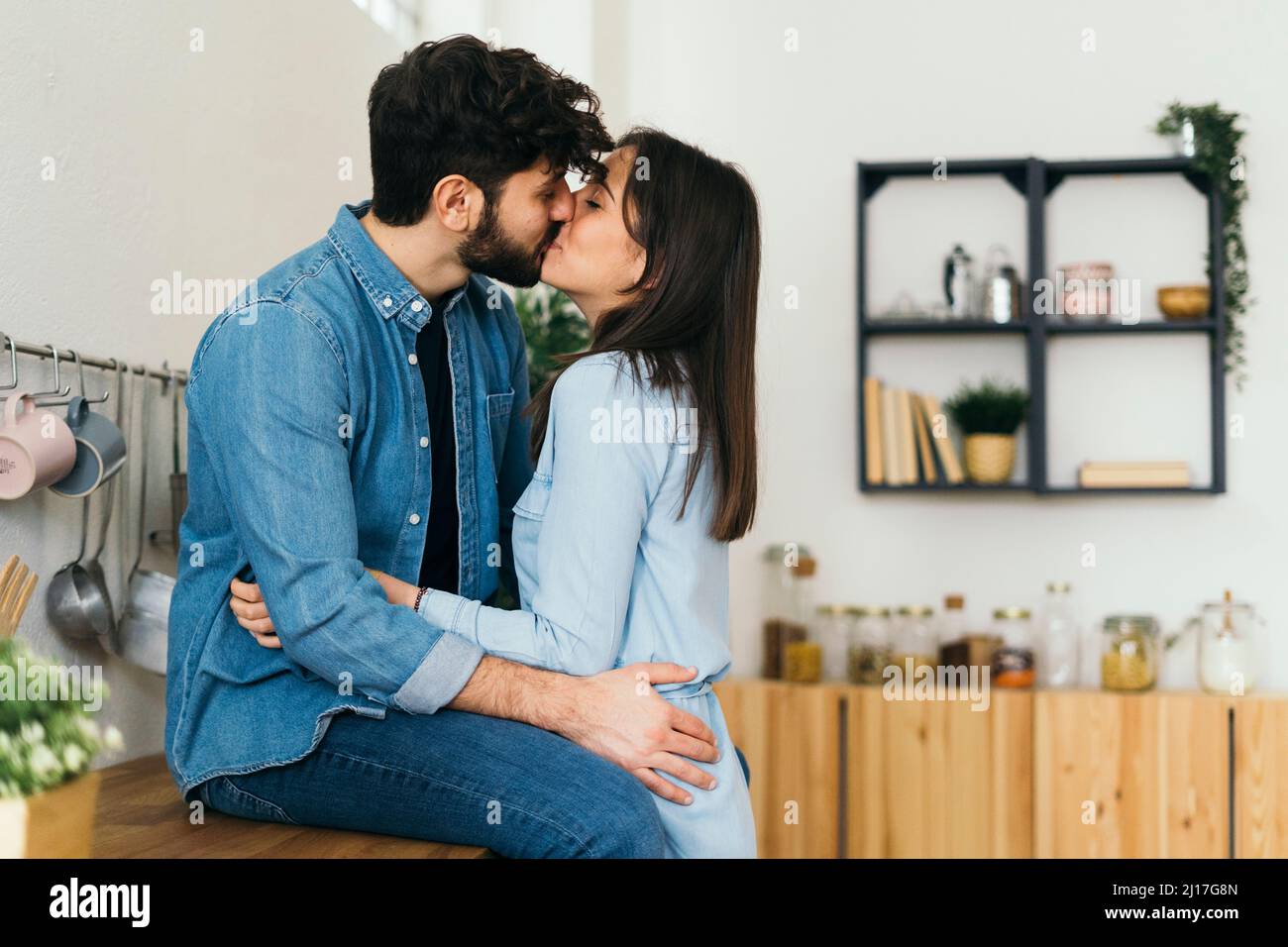 Affectionate couple kissing each other in kitchen Stock Photo