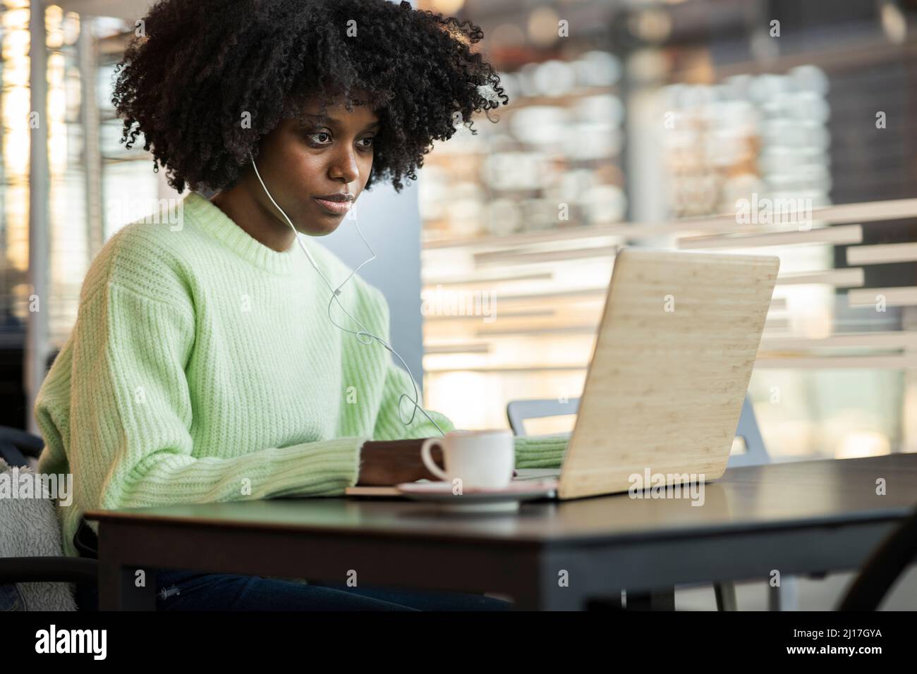 Woman using laptop sitting in cafe Stock Photo