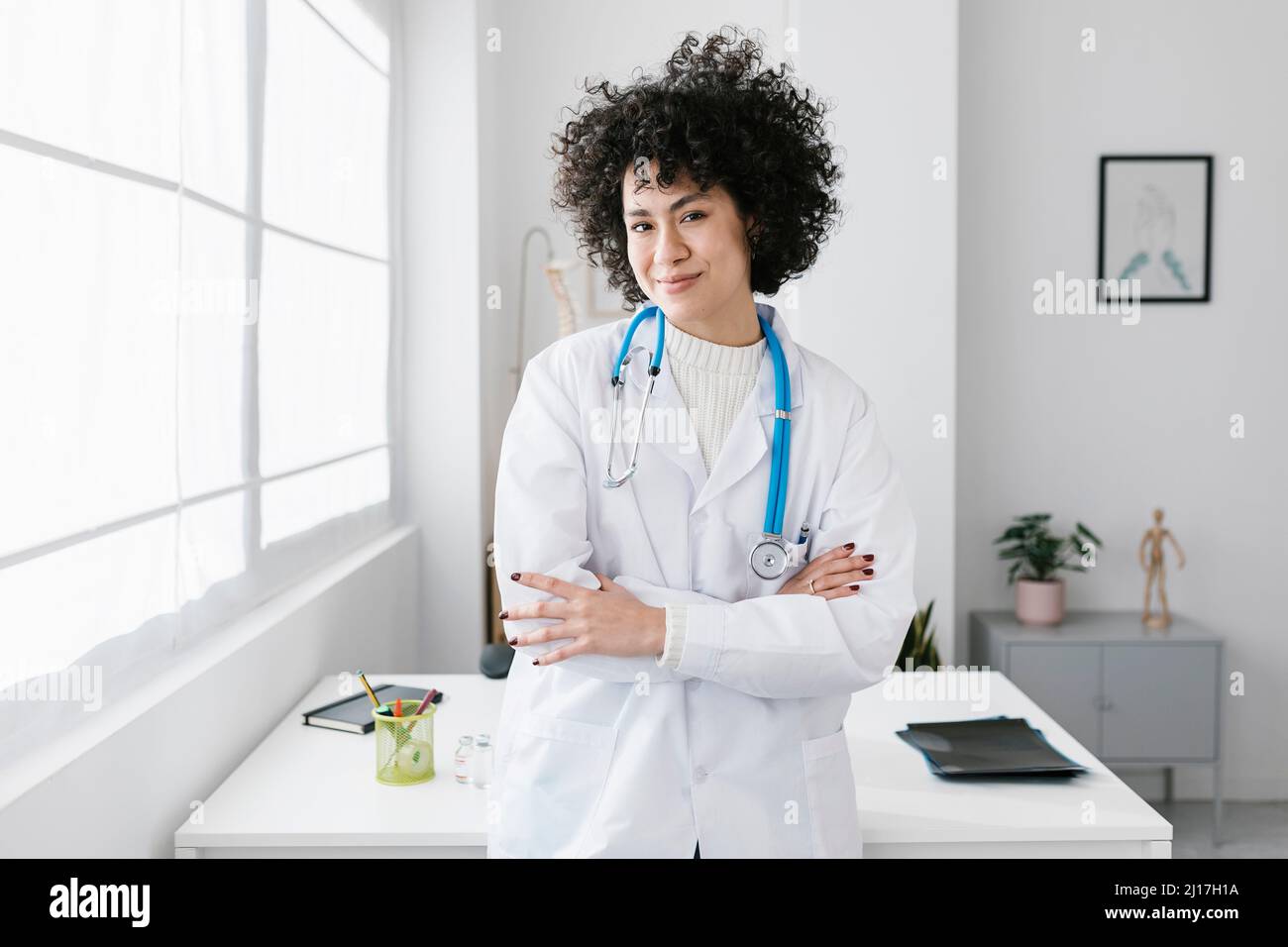 Doctor standing smiling arms hi-res stock photography and images - Alamy