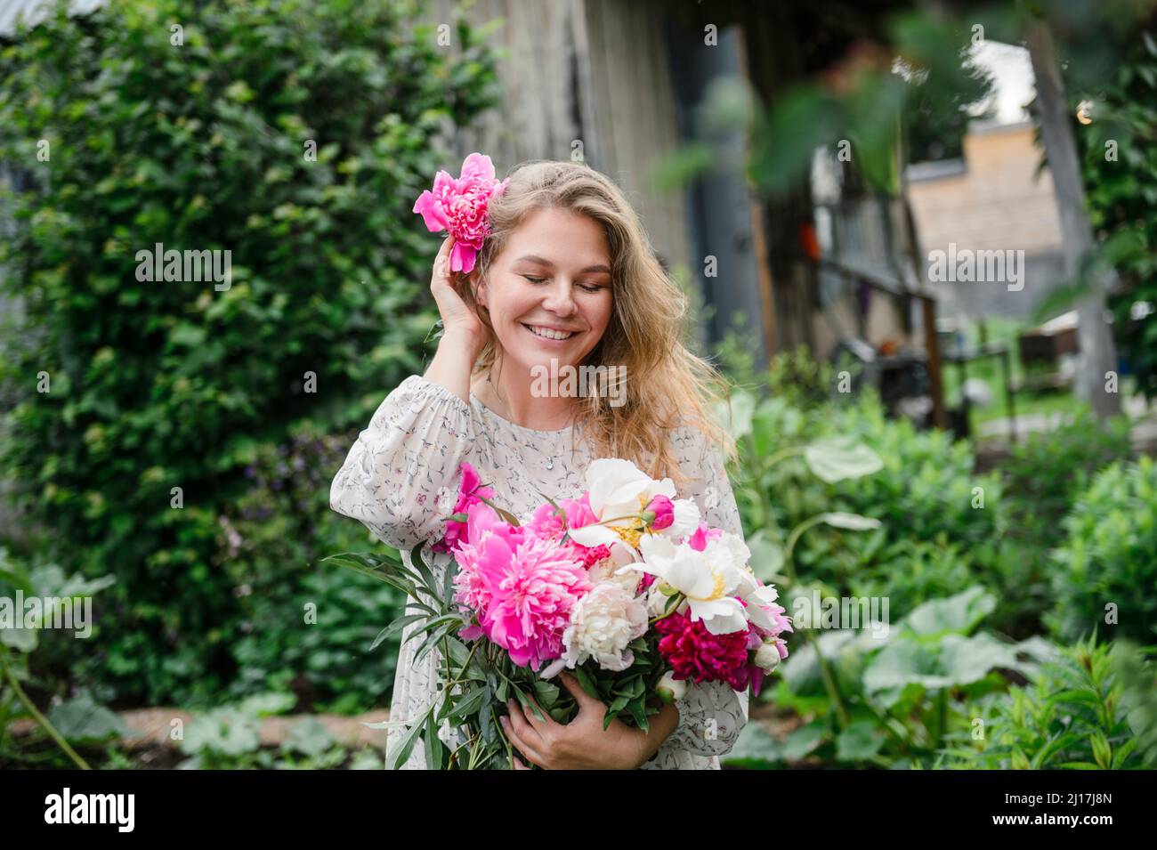 Woman in front of flower garden hi-res stock photography and images - Alamy
