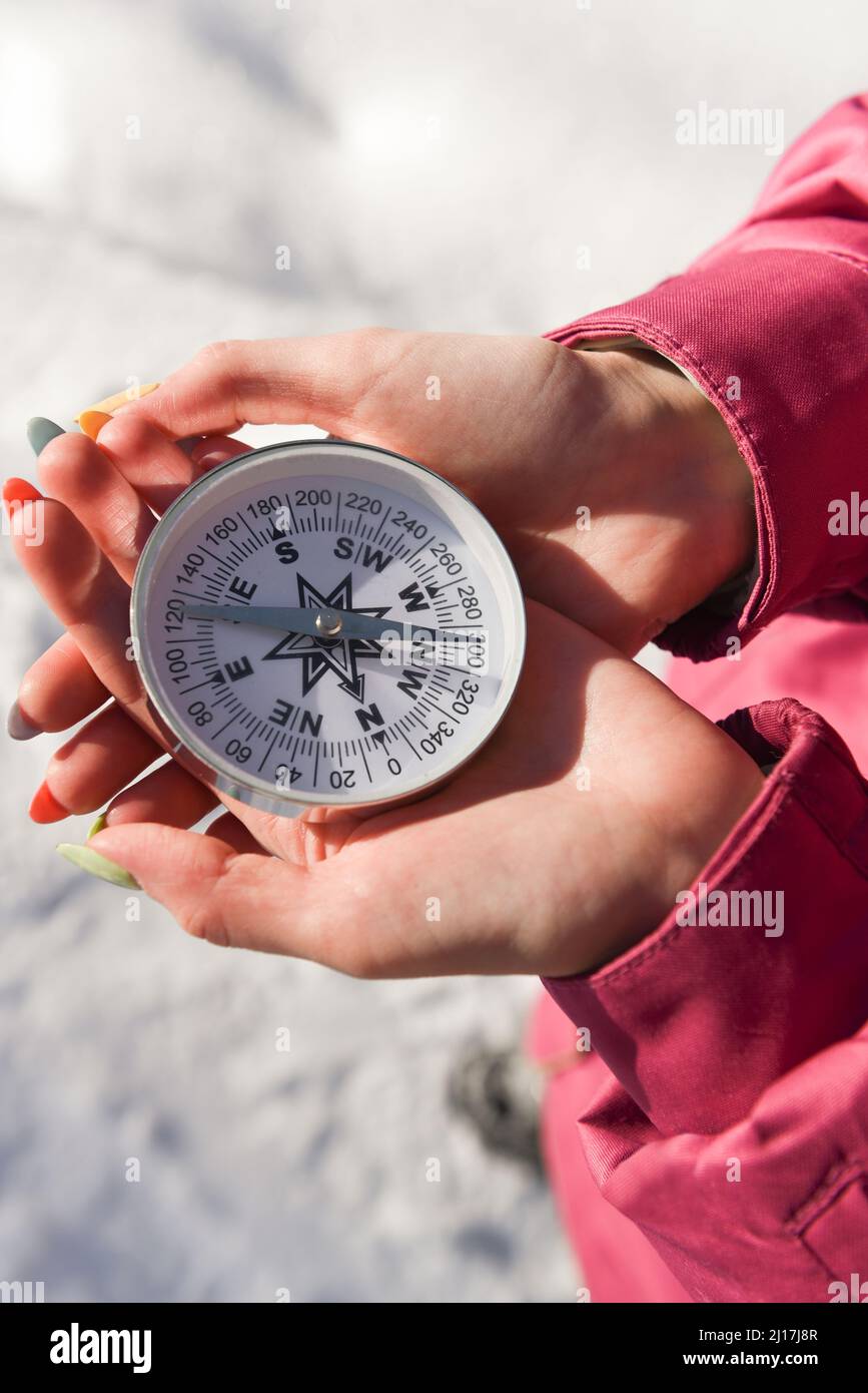 Woman with hands cupped holding navigational compass on sunny day Stock Photo