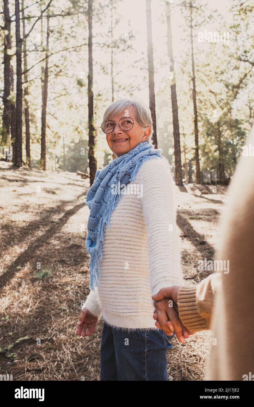 Smiling senior couple holding hands in forest Stock Photo