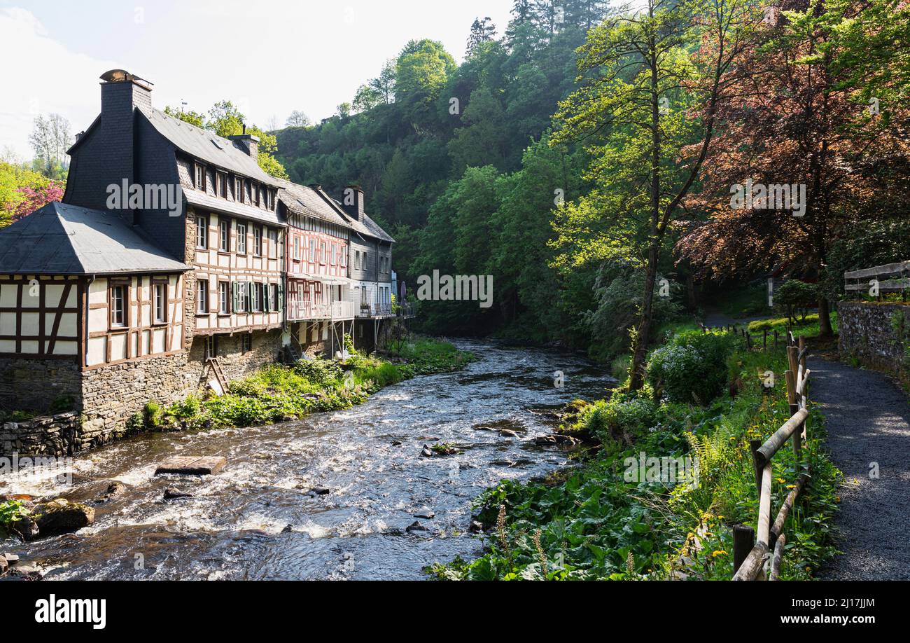 Germany, North Rhine-Westphalia, Monschau, Historic half-timbered townhouses standing on bank of Rur river in spring Stock Photo