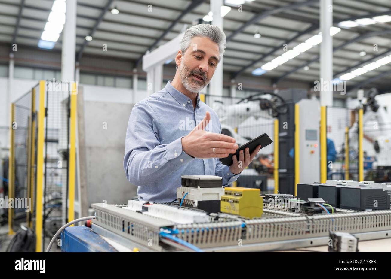 Developer discussing about machine through video call on tablet PC in factory Stock Photo