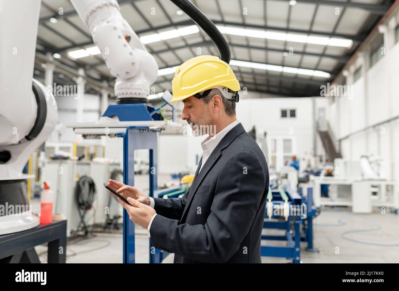 Engineer using tablet PC standing in factory Stock Photo