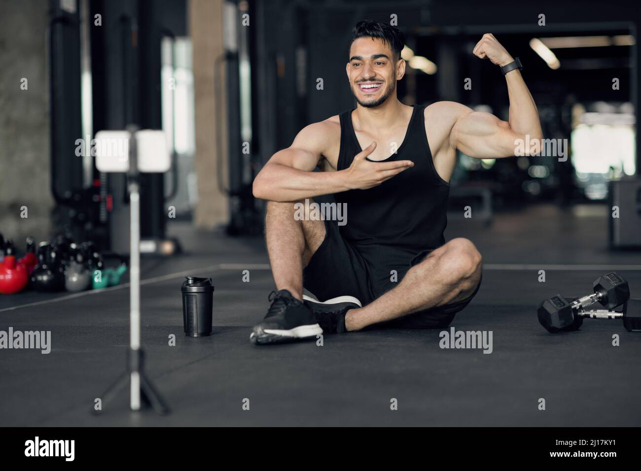 Online Workouts. Handsome Arab Male Bodybuilder Recording Videos For His Fitness Blog Stock Photo