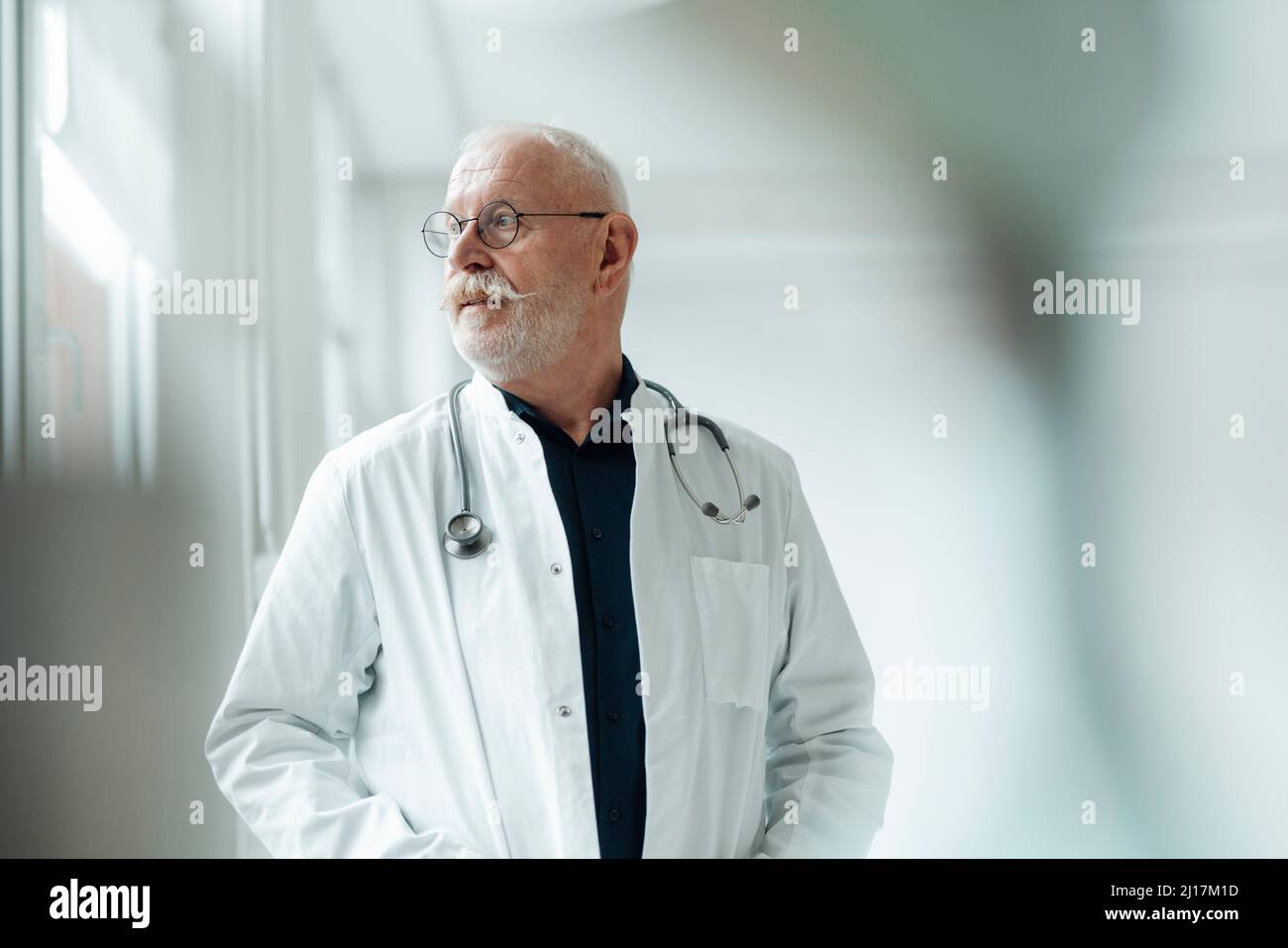 Senior doctor wearing eyeglasses standing in hospital Stock Photo Alamy