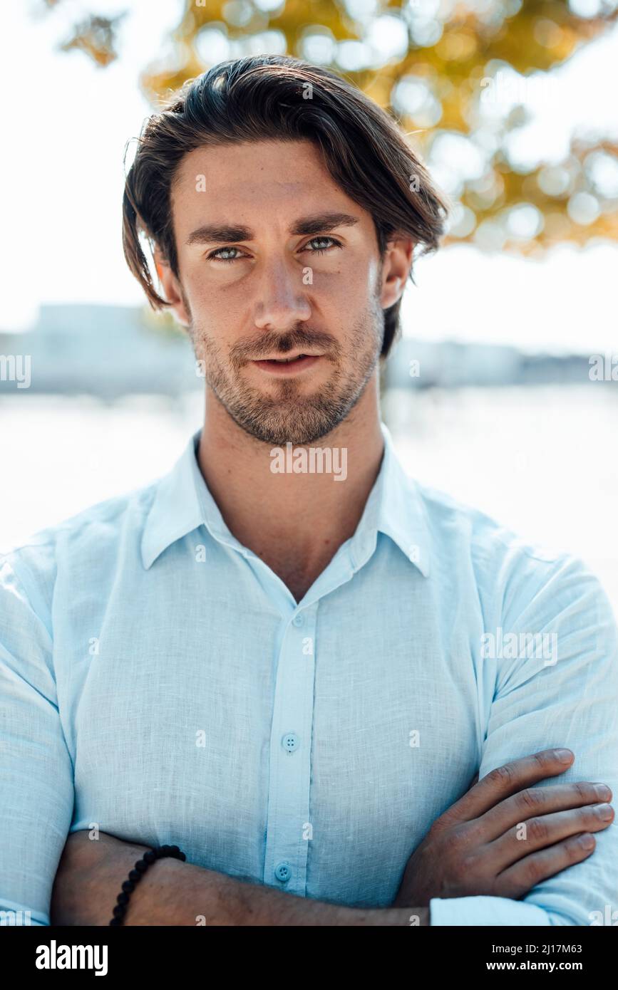 Handsome businessman standing with arms crossed Stock Photo - Alamy