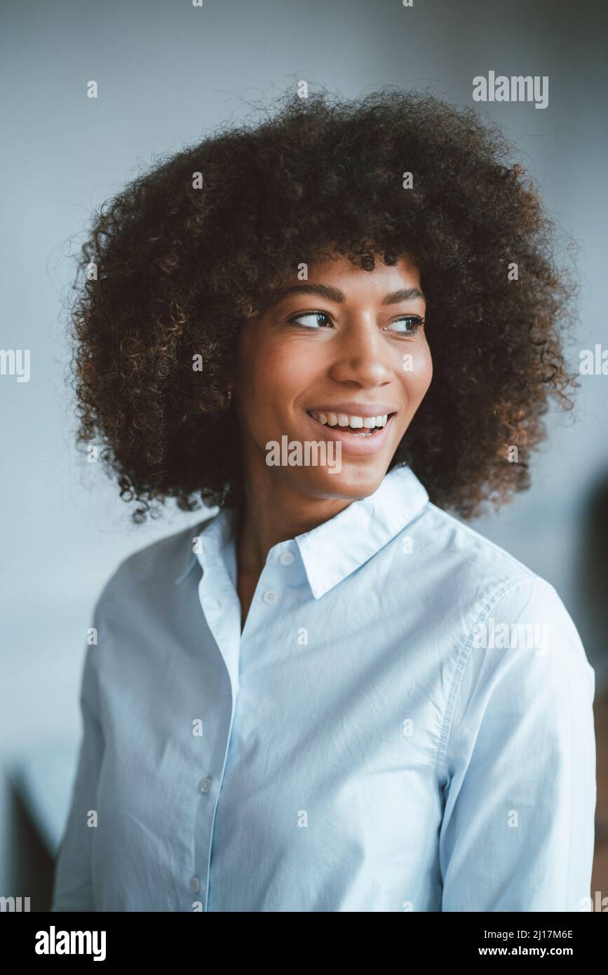 Smiling businesswoman day dreaming at work place Stock Photo