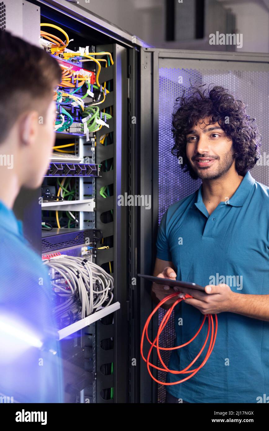 IT support discussing with trainee in server room at industry Stock Photo