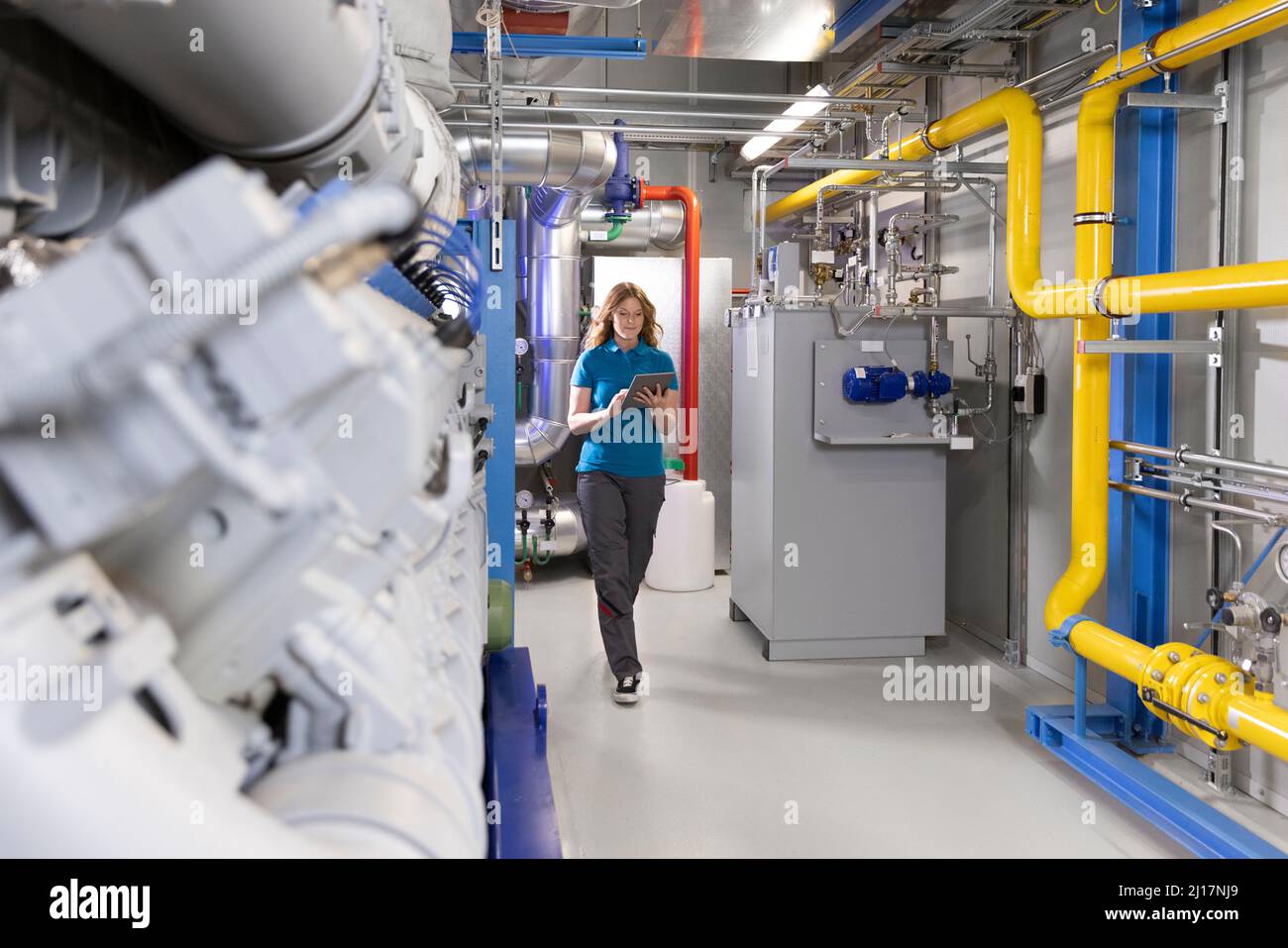 Technician using tablet PC walking in factory Stock Photo