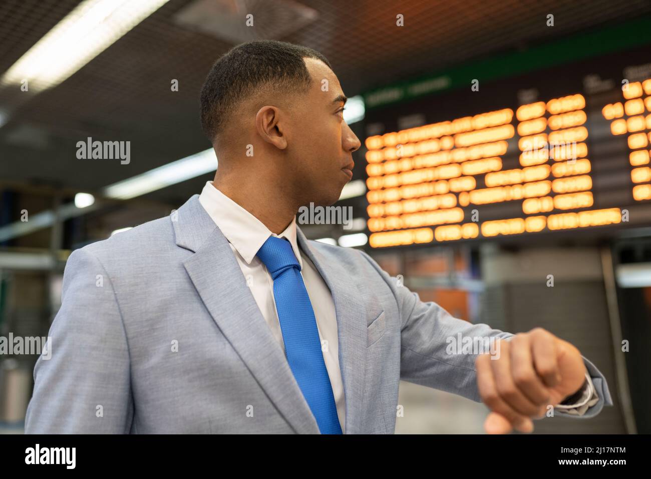 Businessman checking time waiting at train station Stock Photo