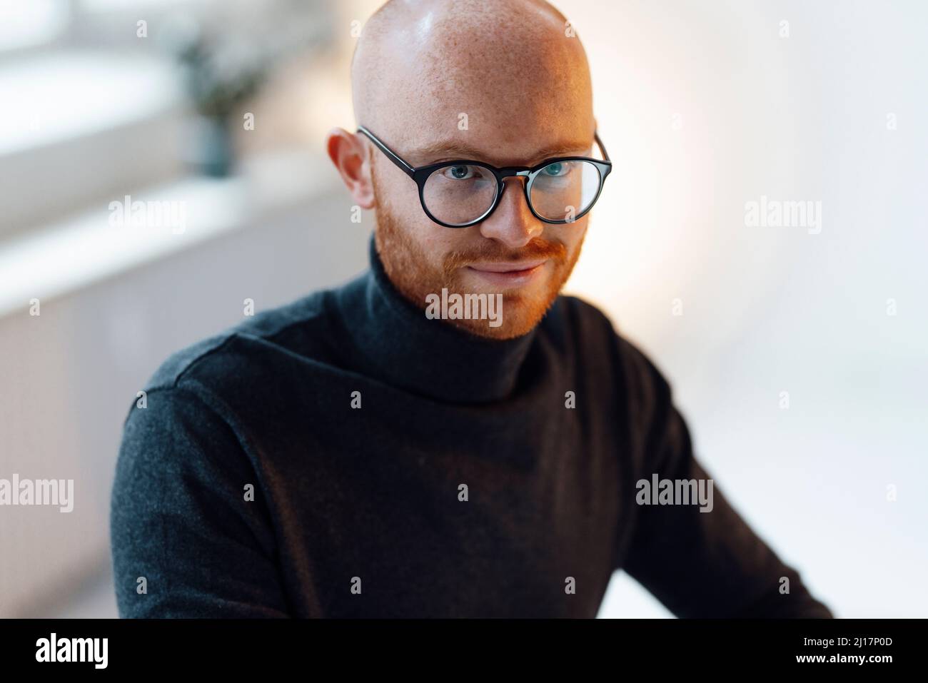 Confident businessman wearing eyeglasses sitting in office Stock Photo
