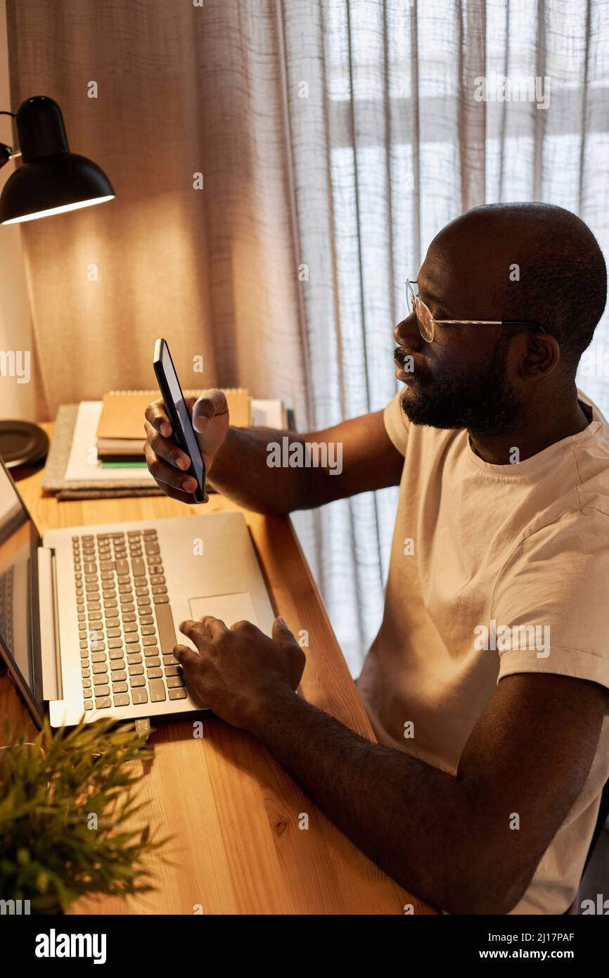 Businessman text messaging through smart phone working at home office Stock Photo