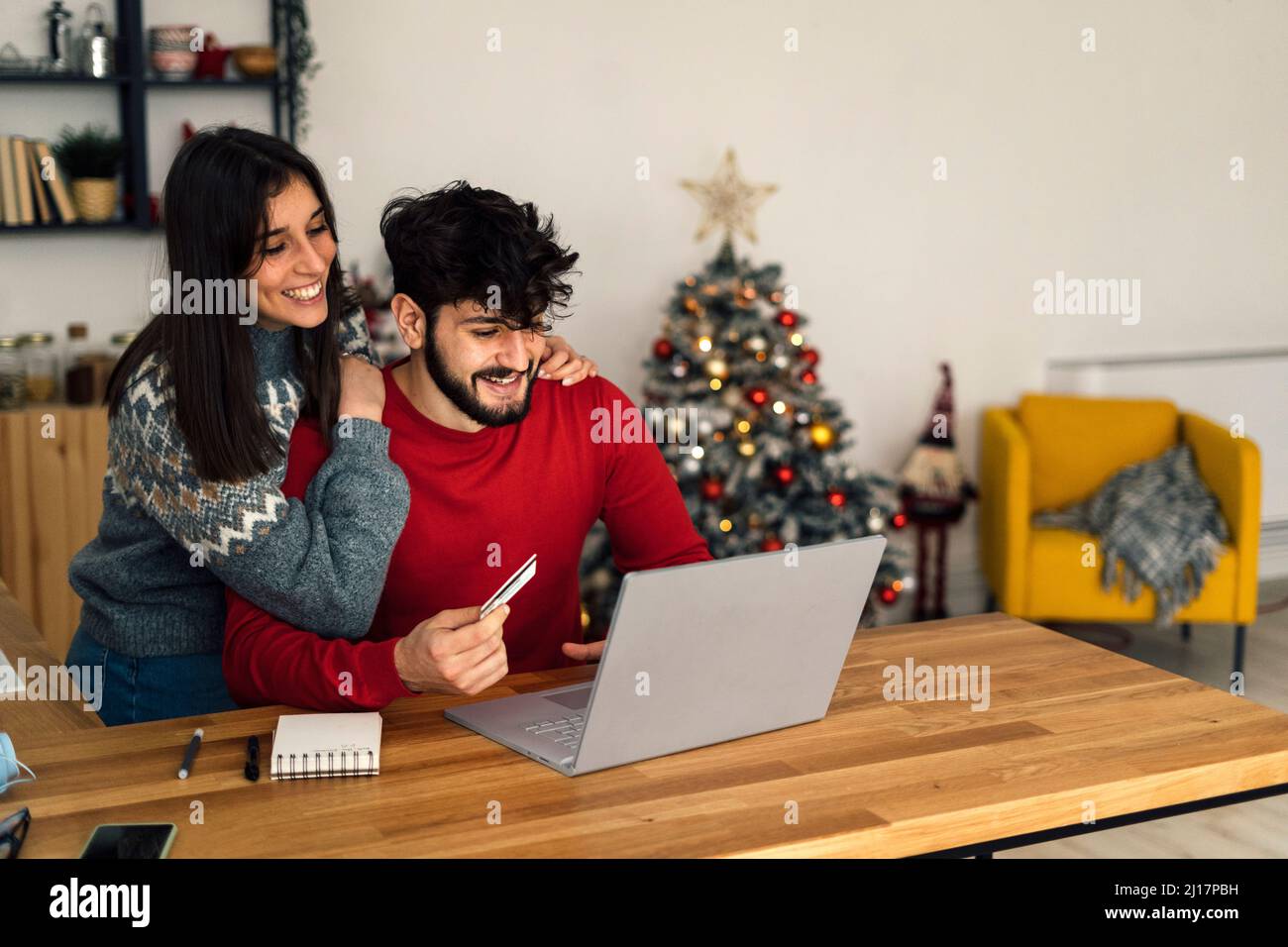 Happy couple doing online shopping through laptop at home Stock Photo