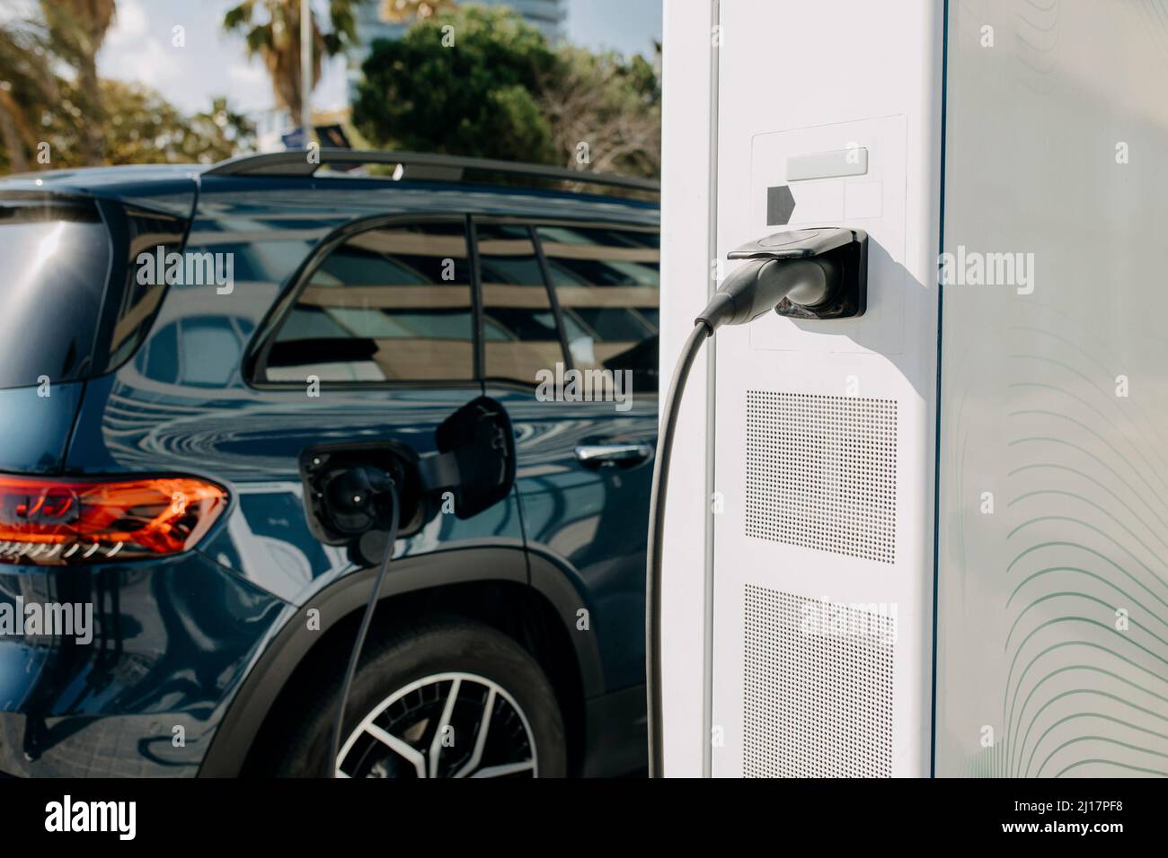 Hybrid car charging at electric charging station Stock Photo - Alamy