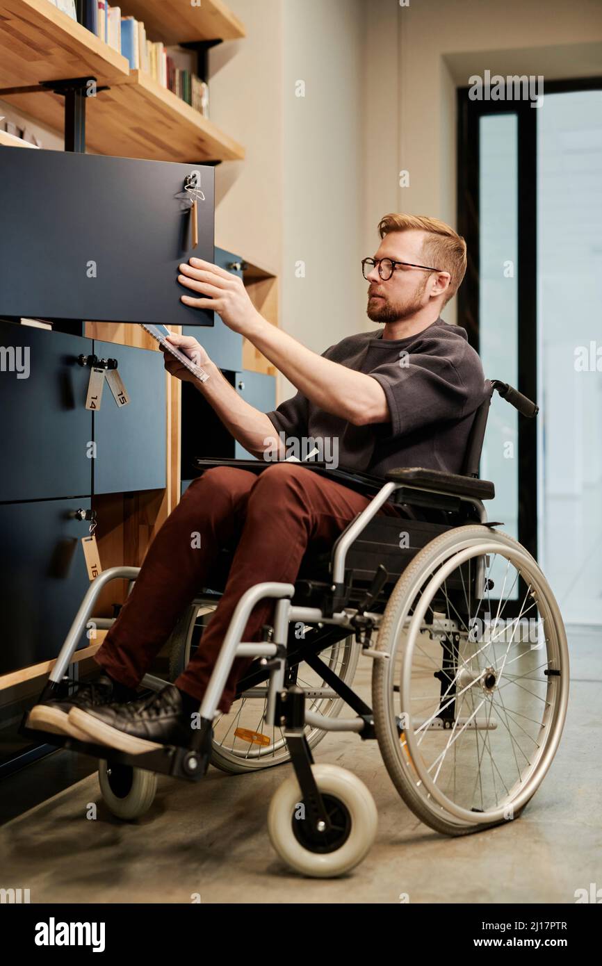 Disabled businessman searching documents in cabinet at office Stock Photo