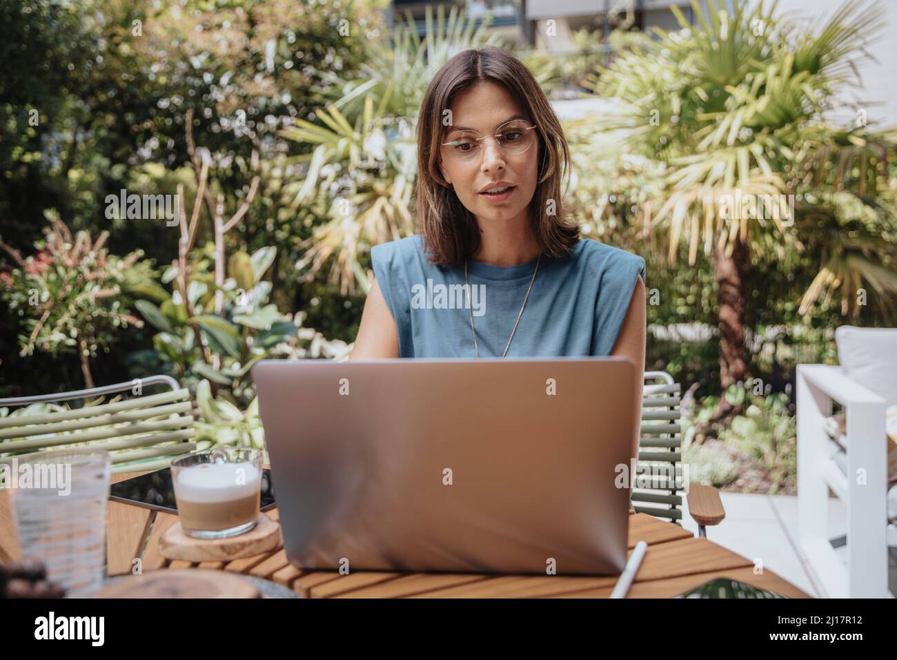 Freelancer working on laptop in back yard Stock Photo