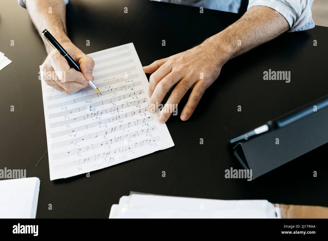 Musician writing musical notes by tablet PC at table Stock Photo
