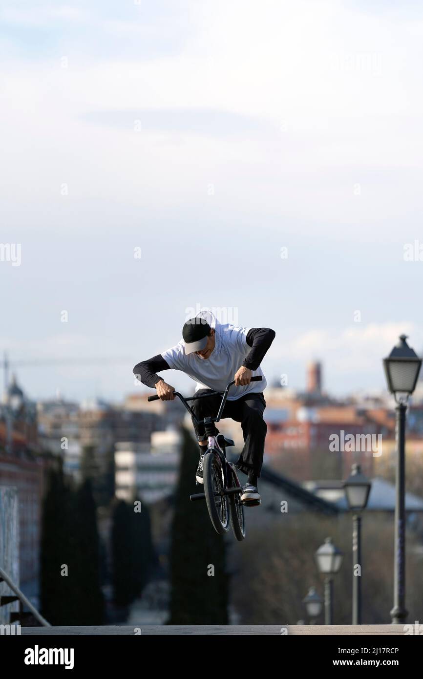 Man doing trick on bicycle in city at weekend Stock Photo
