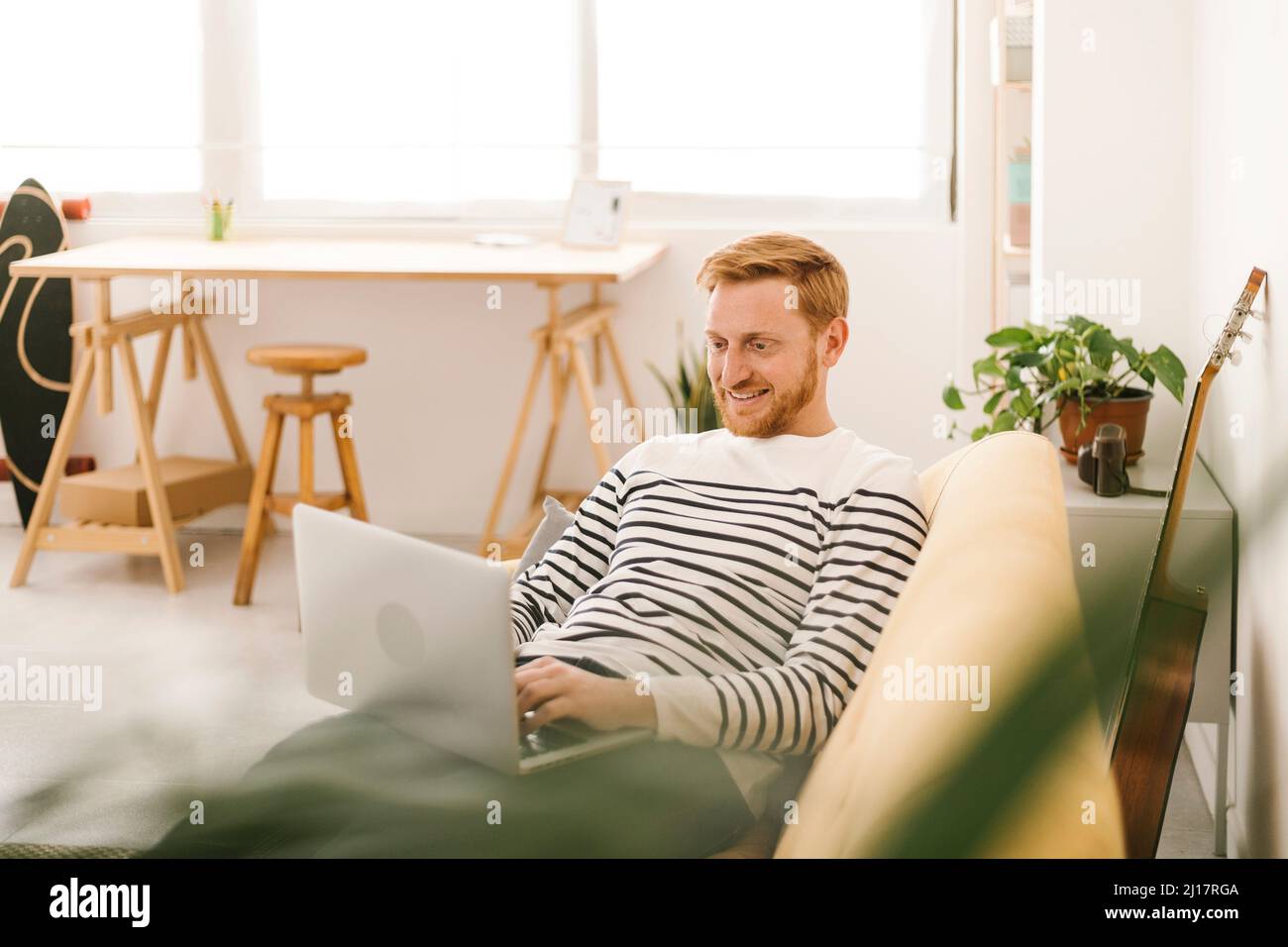 Young man laptop sofa hi-res stock photography and images - Alamy