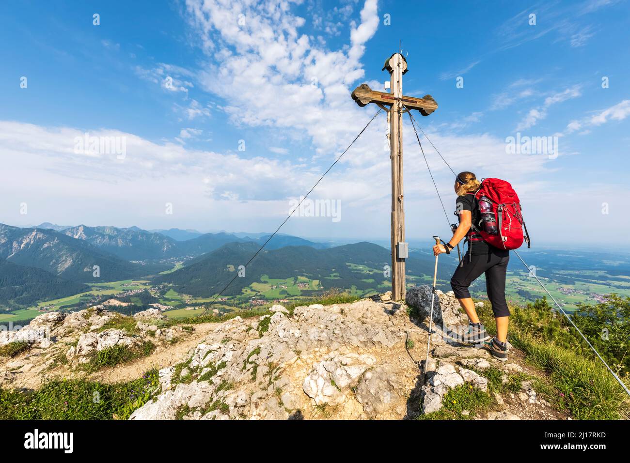 Female hiker standing in front of Bockstein summit cross Stock Photo