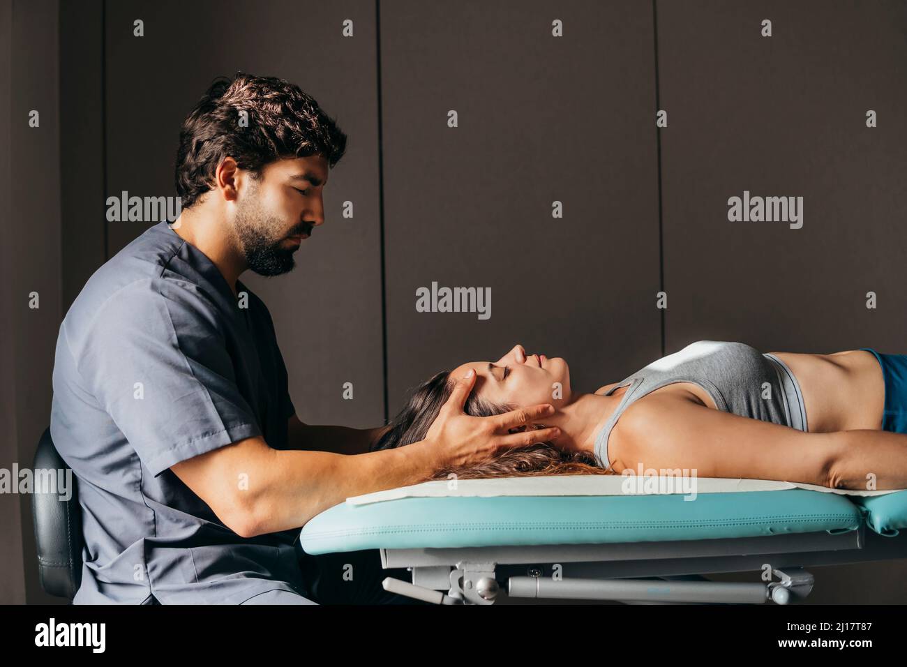Physiotherapist giving head massage to woman in medical clinic Stock Photo
