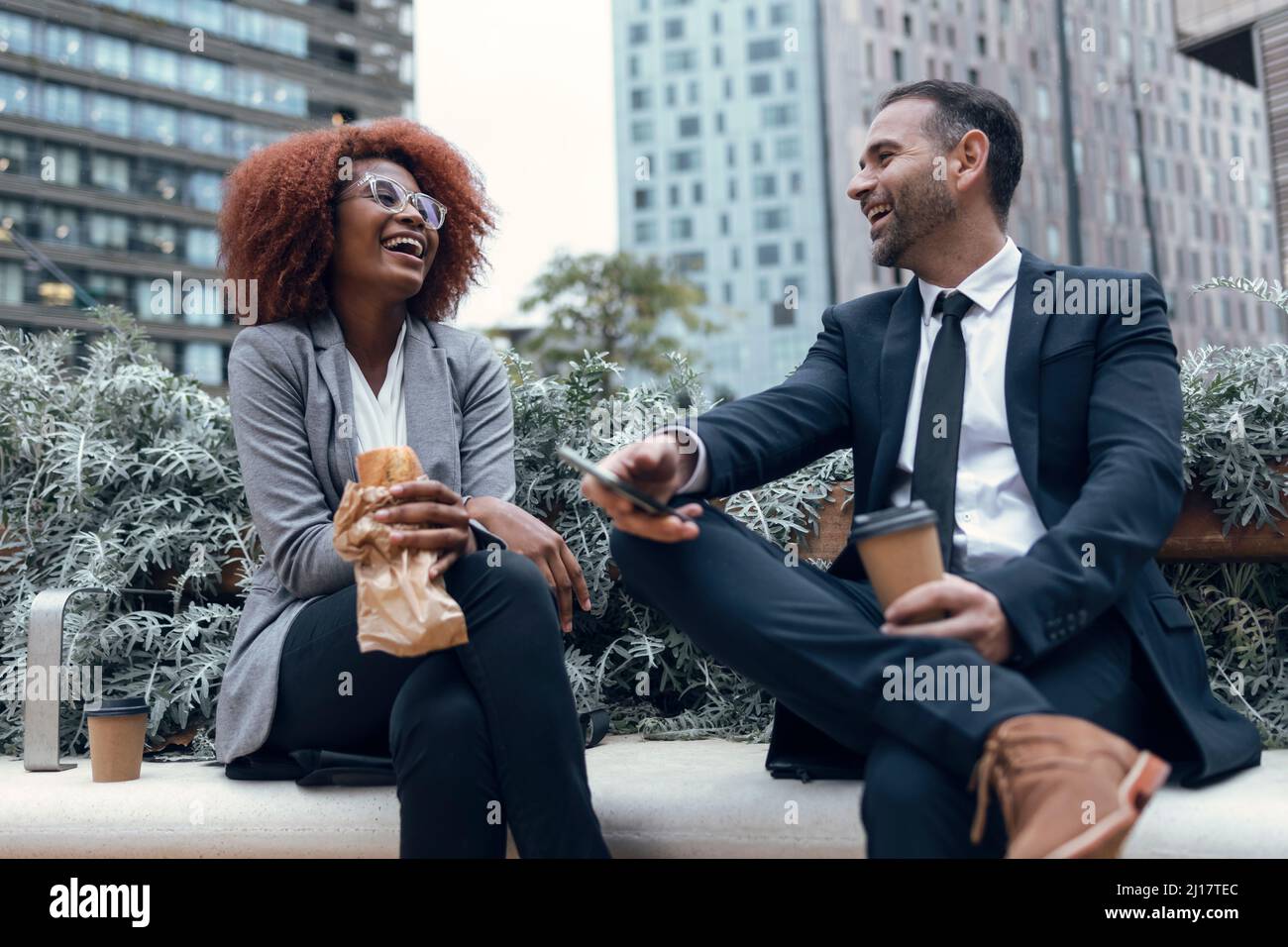Two business colleagues talking while sitting outdoors Stock Photo