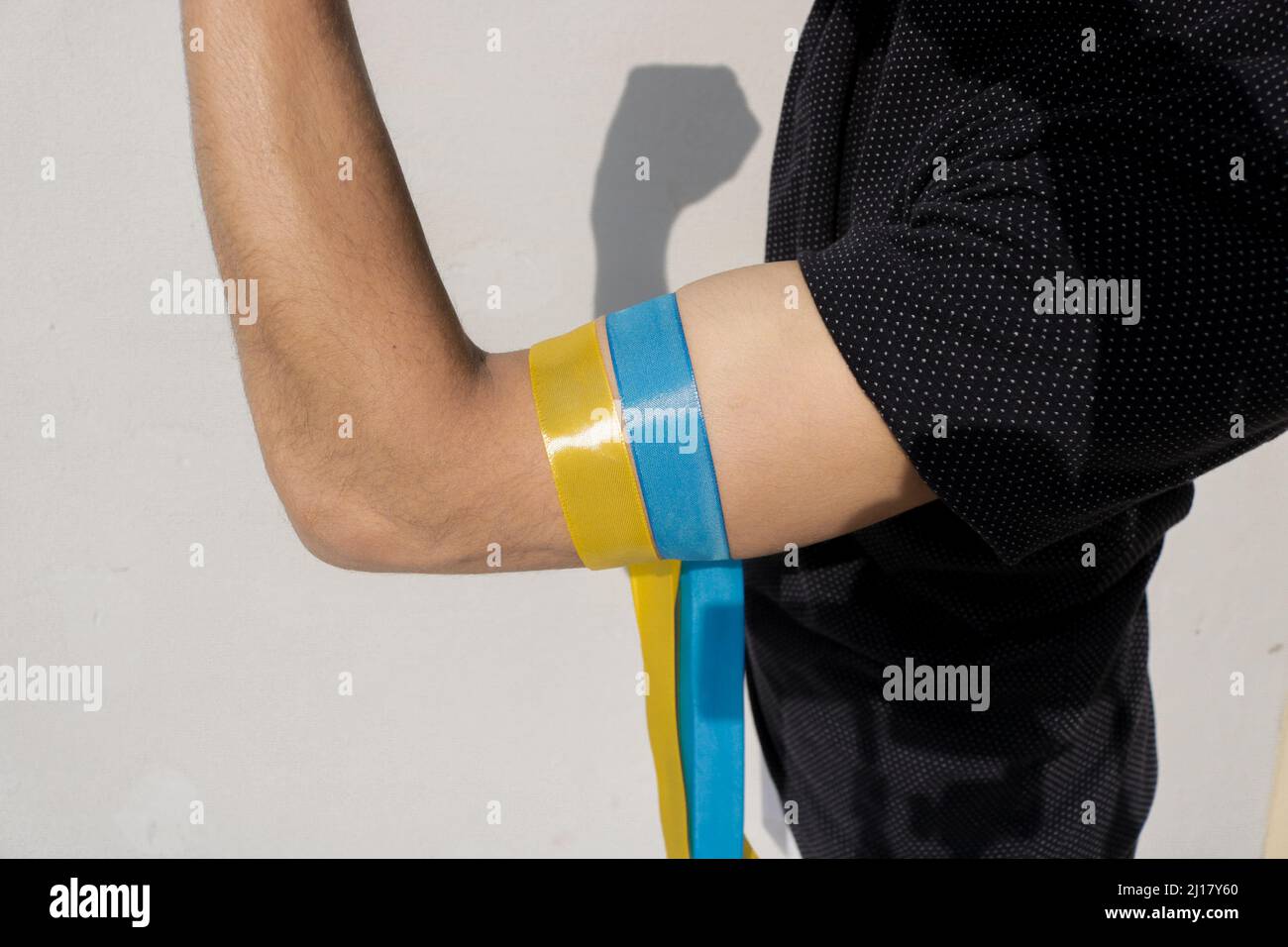 Solidarity with Ukraine abstract background with Ukraine flag painted on fist. Patriotic and togetherness concept. Stand with Ukraine backdrop. Stock Photo