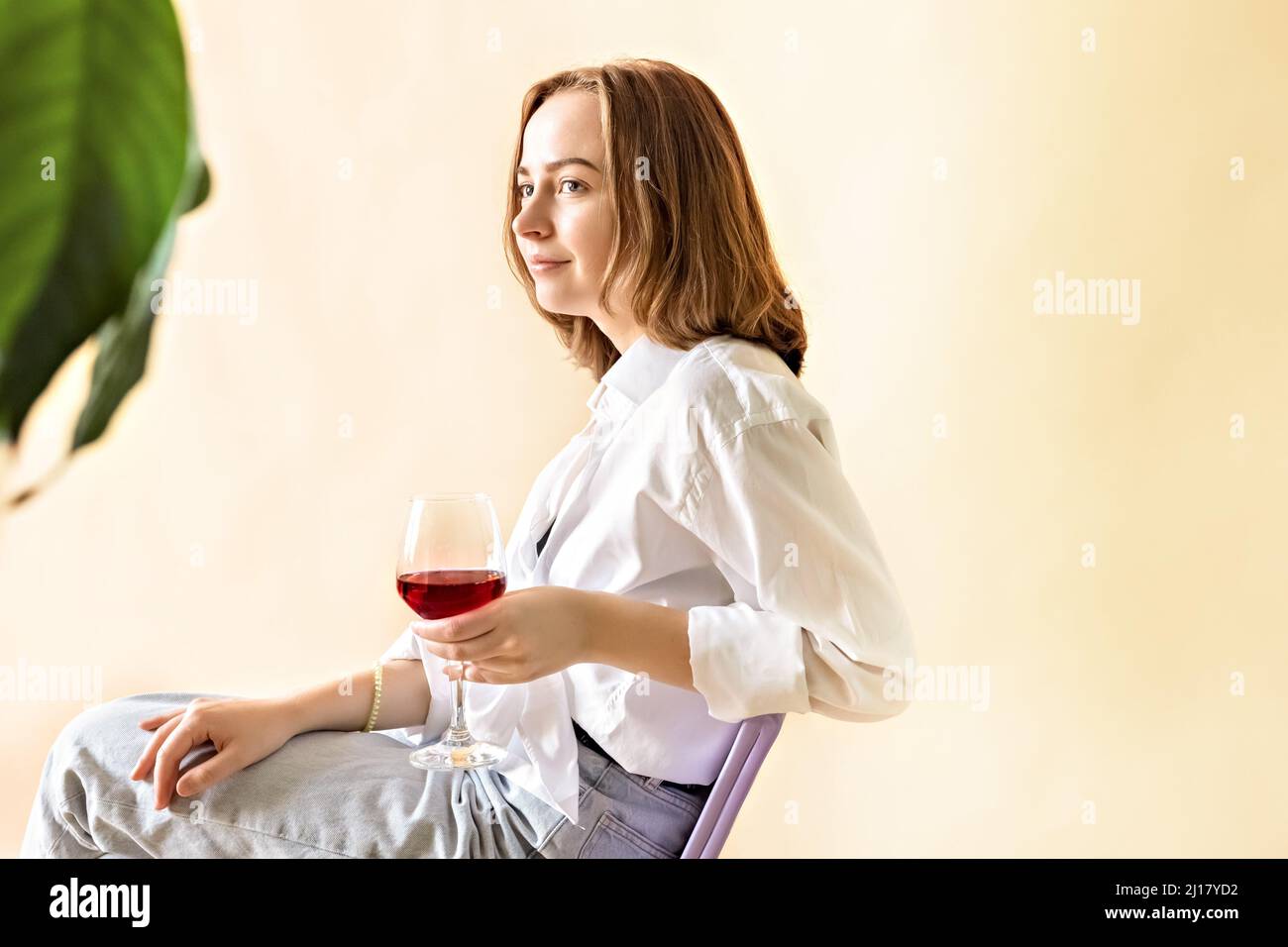 Portrait of a young woman with a glass of red wine in her hands. Spring ...