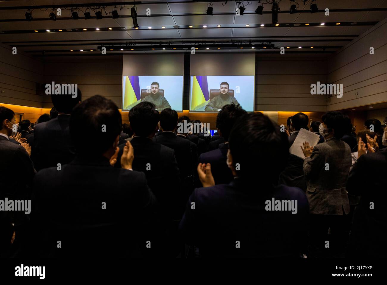 Tokyo, Japan. 23rd Mar, 2022. Members of the Japan's lower house parliament applaud at the end of Ukrainian President Volodymyr Zelensky speech via videolink at the House of Representatives office building in Tokyo. Credit: SOPA Images Limited/Alamy Live News Stock Photo