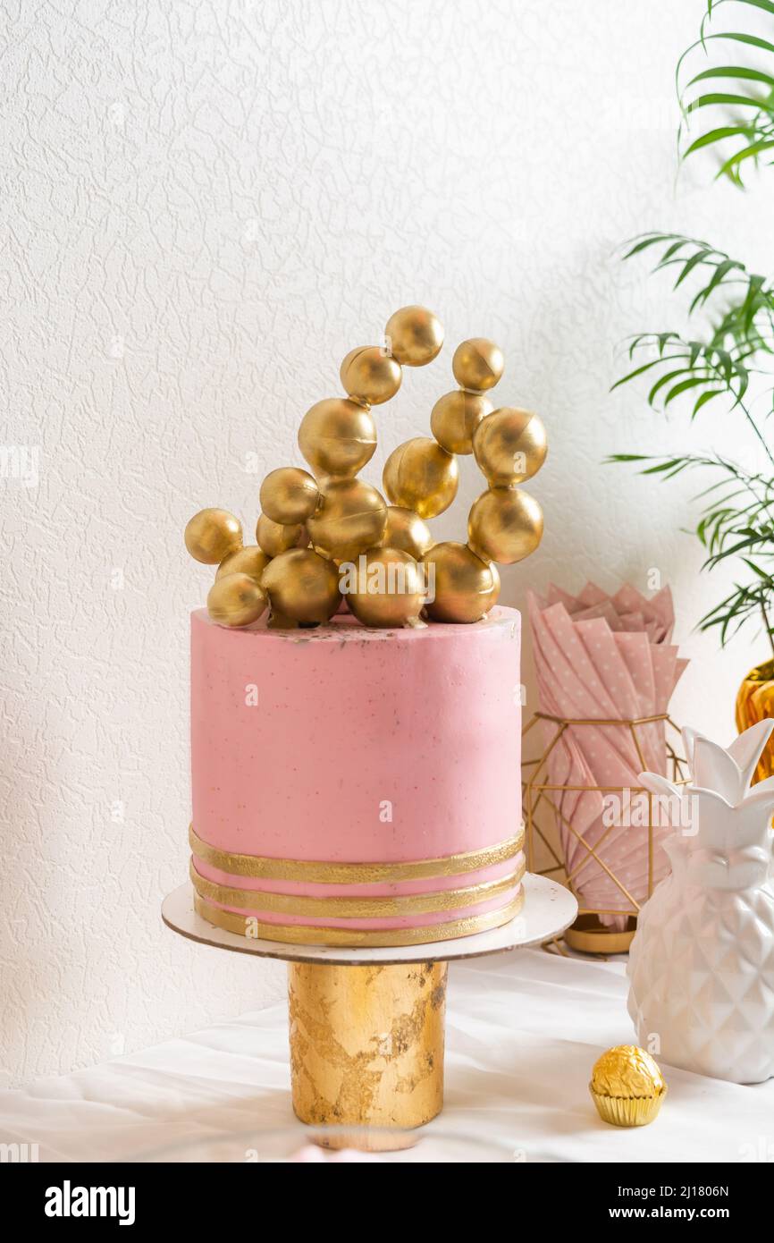 Holiday birthday table with cake and ballons. Pink and golden decoration Stock Photo