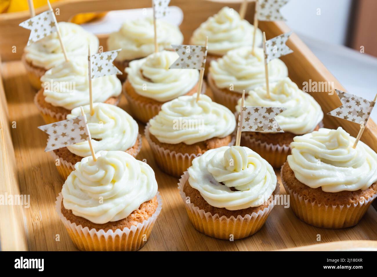 Tasty cupcakes with cream on wooden tray on holiday table with flags Stock Photo