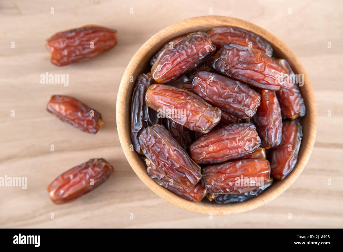 Date fruit in bowl on wooden background, top view Stock Photo