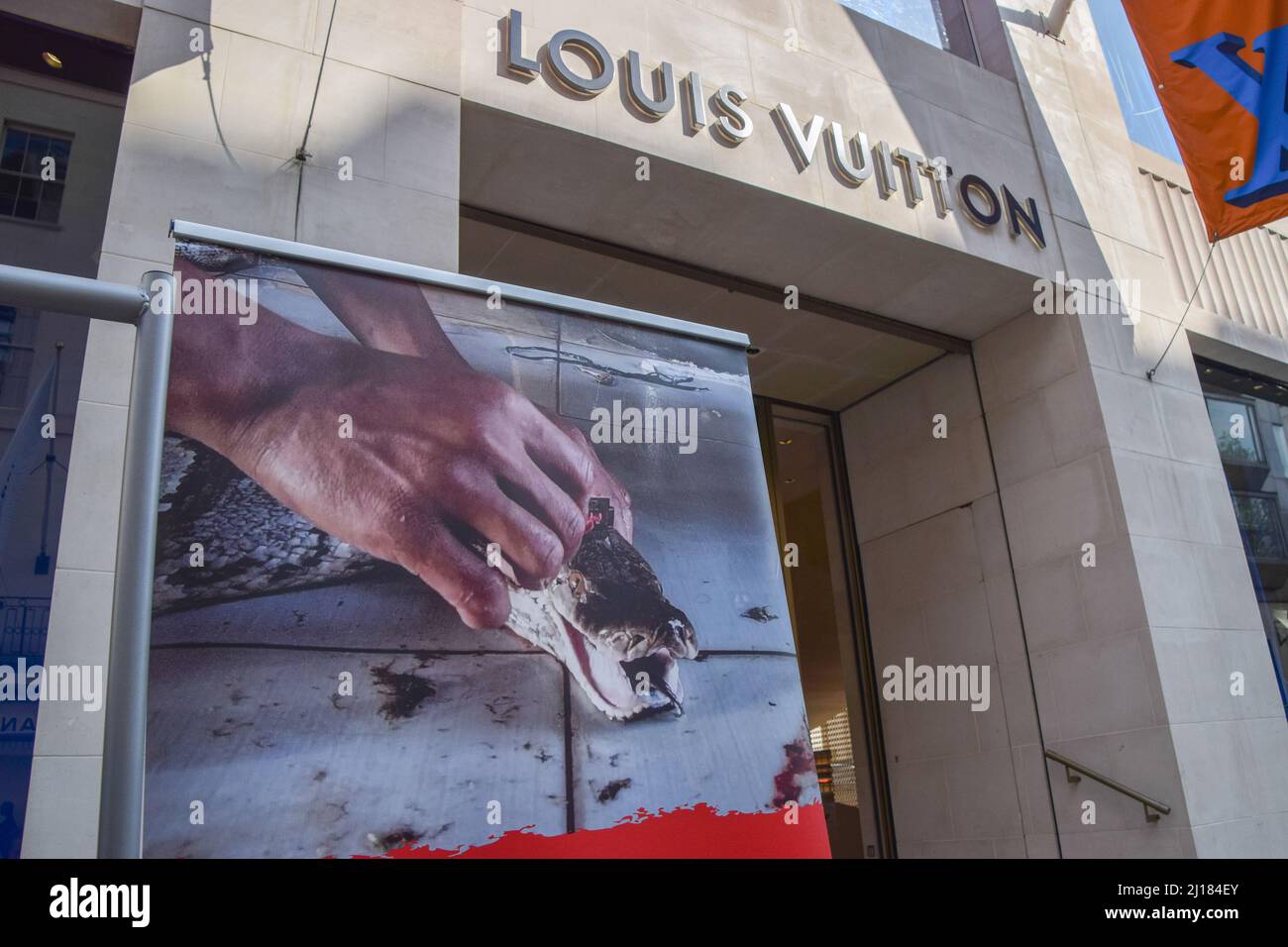 London, England, UK. 23rd Mar, 2022. PETA activists wearing snake costumes  and covered in fake blood were 'skinned alive' outside the Louis Vuitton  store in New Bond Street in protest against the