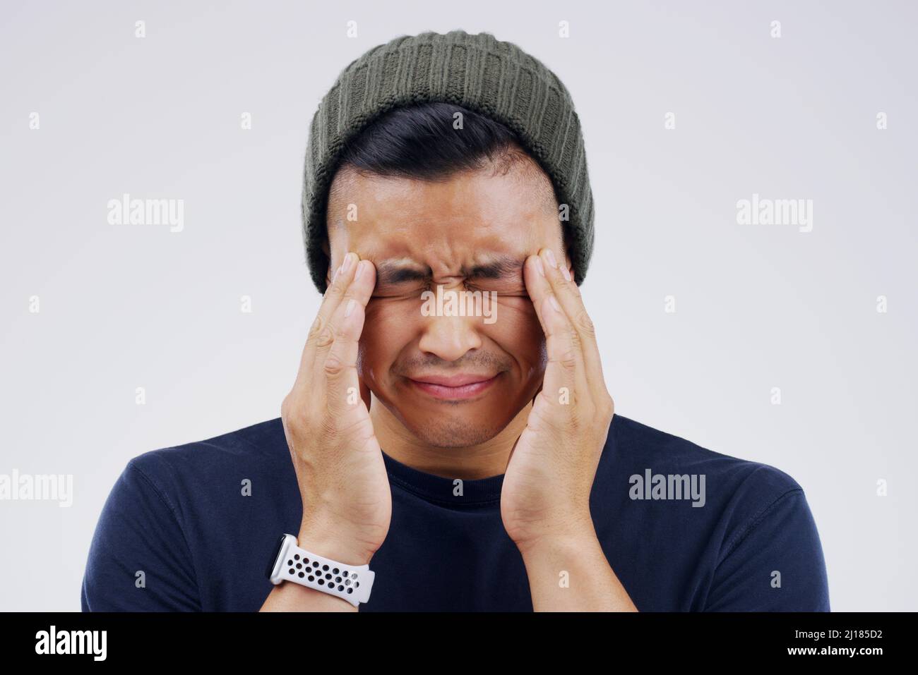 I cant stand this pain any longer. Shot of a young man holding his head